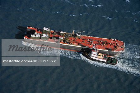 Aerial view of tugboat pushing tanker.