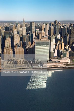 Aerial view of Midtown Manhattan, New York with United Nations Headquarters building reflecting in East River.