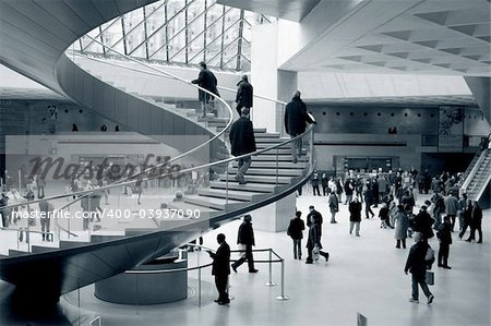 people in the entrance hall in the louvre, paris