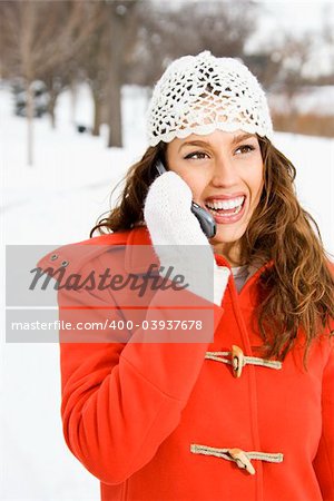 Caucasian young adult female on cell phone outdoors in the snow.