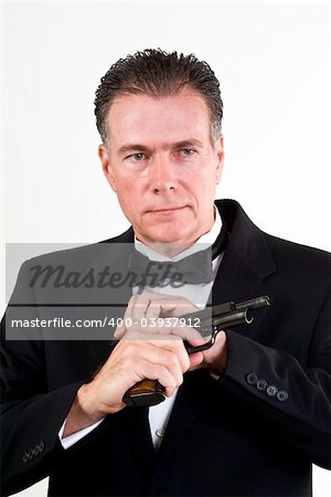 Man in formal attire, cocking a 9mm automatic weapon, taken in front a white background.