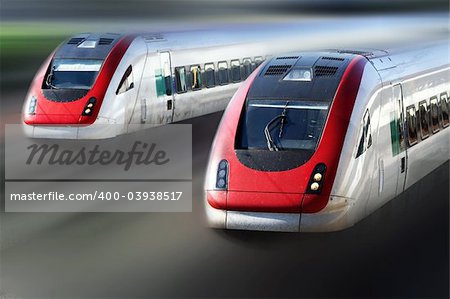 Two trains travelling very fast along its tracks.