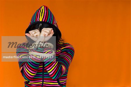 woman wearing a multi-colored hoody, with wrists bound with rope