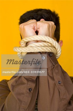 A bussinessmen tiedup by his fists with a yellow background