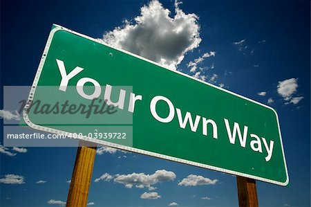 "Your Own Way" Road Sign with dramatic blue sky and clouds.