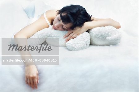 Beautiful young woman sleeping with plush bear