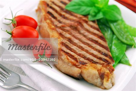 Grilled New York steak served on a plate with vegetables
