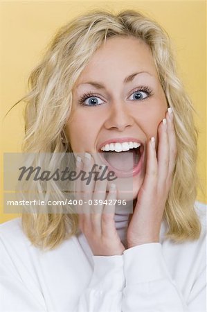 Studio shot beautiful young blond woman looking happily surprised