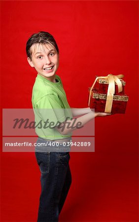 A smiling boy in casual clothes carrying gifts tied with ribbon