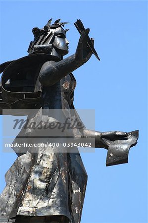 Sculpture with a feather and the book on a blue background