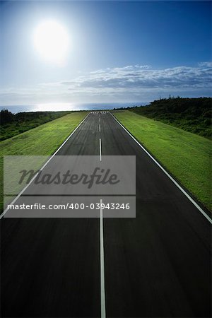 Airplane runway with Pacific ocean in background.