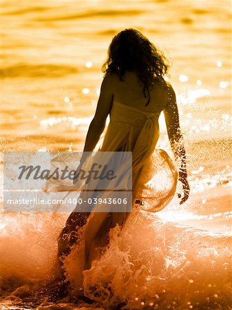 Woman on the beach at sunset