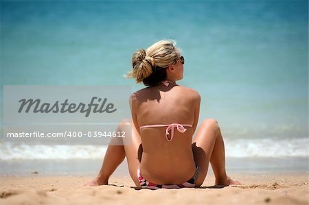 Blond girl sitting on the beach