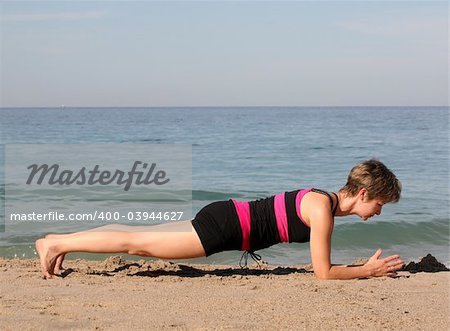 Woman doing yoga exercise on the beach