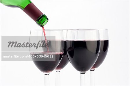 Plusieurs verres de vin rouge est coulé sur un fond clair.