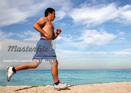 Young man running alone on the beach