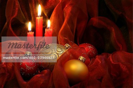 Christmas Candles & Baubles on a red background / horizontal