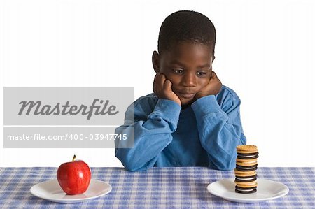 A young African American boy gets ready for a snack - studio shot isolated on white.