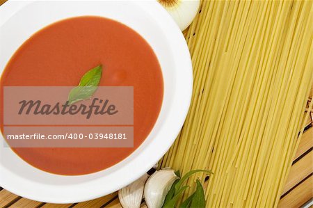 Pasta background - Spaghetti, tomato sauce, garlic and basil leaves on wood background