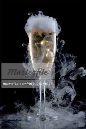 Glass of white wine isolated over black background, with a lot of smoke