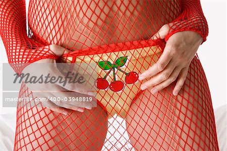 Caucasian woman with hands on cherry underwear in mesh clothing.