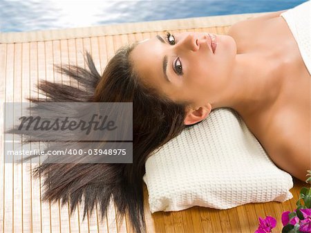 portrait of a beautiful brunette laying down on a wood carpet