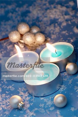 Burning candles, ornaments, blue setting