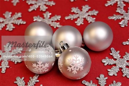 Silver christmas ornaments on red