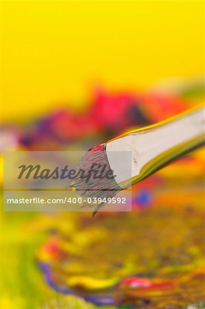 Holding mixing brush with paint in the background