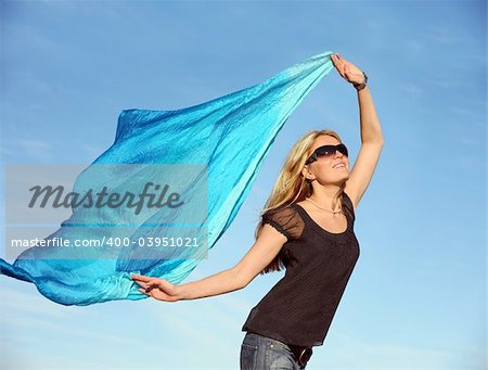 Beautiful blond woman running with a blue scarf