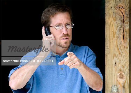 Businessman Pointing while on Cell Phone