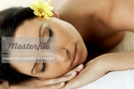 Portrait of Fresh and Beautiful brunette woman laying on bamboo mat around yellow flowers