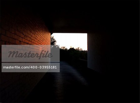 Sunset light shining through a tunnel and reflecting off the bricks.