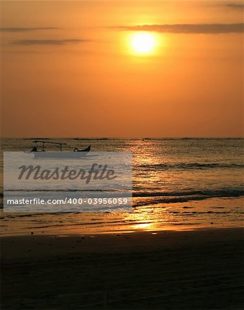 Drifting boat on a sunset. Coast of the Indian ocean. Bali