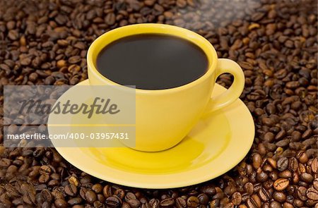 The warm cup of coffe on coffe-grass background