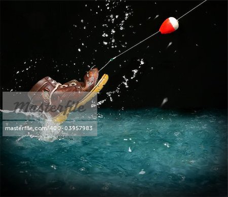 Catching an old shoe with a fishing pole. Splash of water