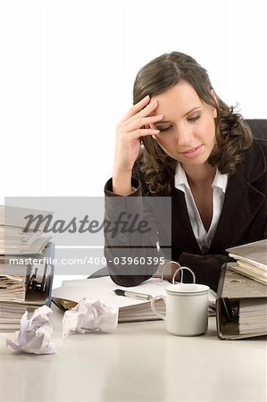 Young woman sitting at her desktop with folders and papers thinking of problems