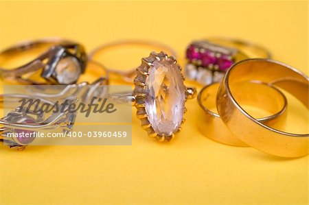 Gold jewellery rings on yellow light bacground