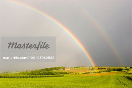 Half rainbow over a rural landscape with intensive colors