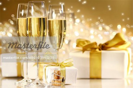 Glasses of champagne with gold ribboned gifts