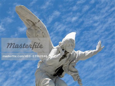 detail of winged angel statue against blue sky