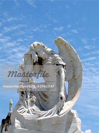 detail of winged angel statue against blue sky