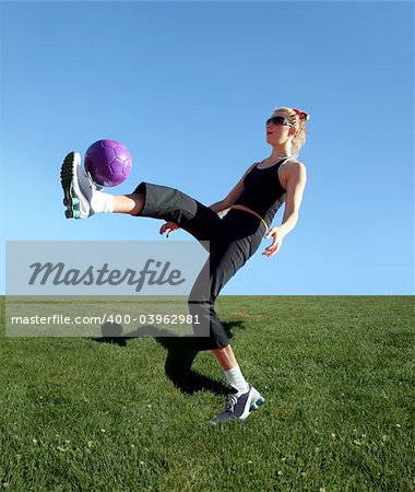 Young woman exercising with the ball in a park