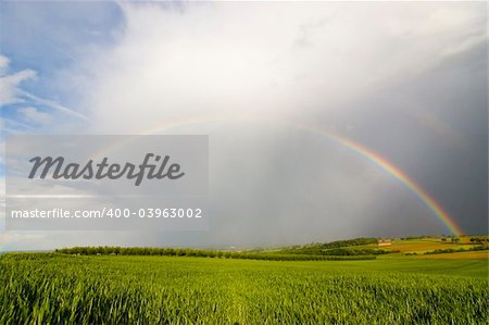 Complete rainbow over a rural landscape on a stormy day