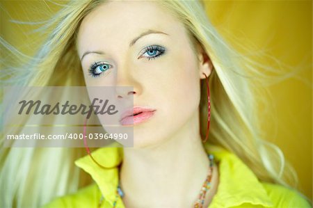 Portrait of beautiful blond woman wearing yellow shirt