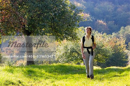 Hiking woman at sunset with the colors of fall