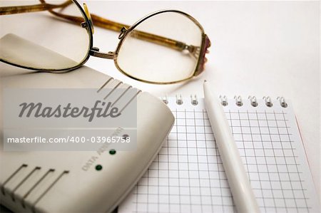 modem, notebook, pen and glasses on a light background