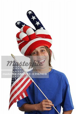 A teen boy in a USA patriotic hat holding a flag and making a silly face.