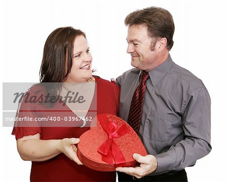 Cute couple exchanging a gift of Valentine candy.  Isolated on white.