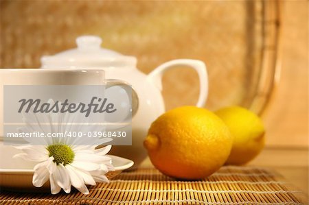 Tea cup  and teapot with lemons on the table